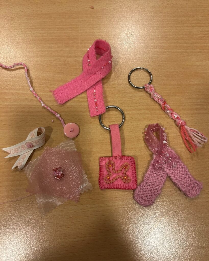 Olika handgjorda rosa band och hängen dekorerade med pärlor, tyg, garn och knappar