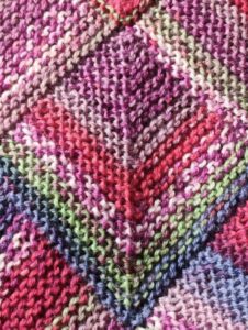 Färgglad dominostickad textil i rosa, lila, rött, grönt och blått