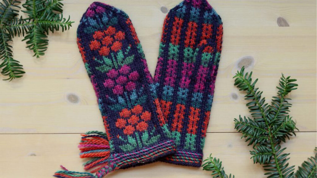 Färgglad handgjord halsduk med blommönster och fransar på ett träbord