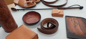 Handgjorda läderföremål: sandaler, bälte, skål, plånbok, armband och dekorerade fodral