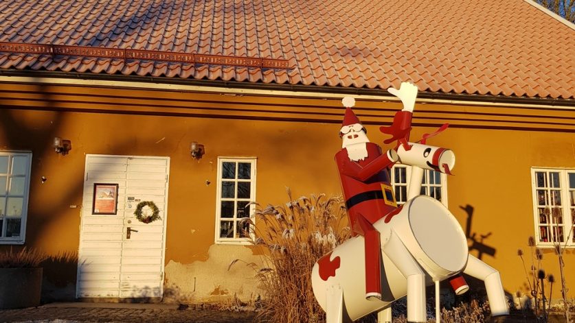 En jultomte vinkar från vit ren utanför Surahammars konst- och hantverksgille