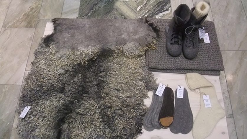Fäll, kängor, strumpor och halsduk i ull utlagda på marmorgolv.