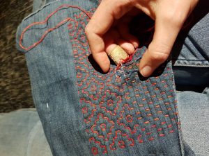 Lagning av ett par jeans med sashikomönster