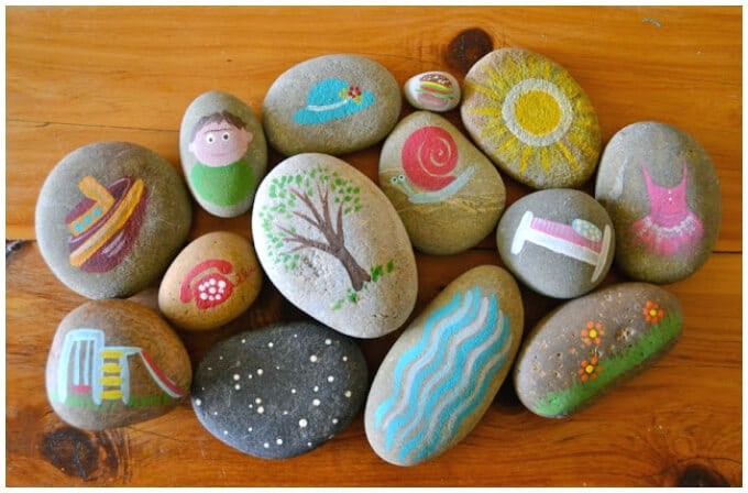 stenar i olika former med målade motiv på