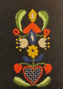 broderade blommor och hjärtan på ett svart bottentyg