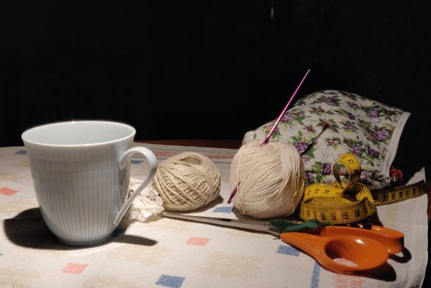 Mugg på bord med sax och garn.
