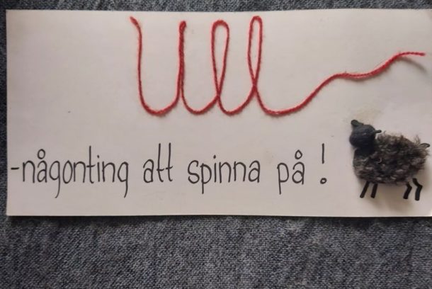 en etikett med texten ull-någonting att spinna på samt ett får