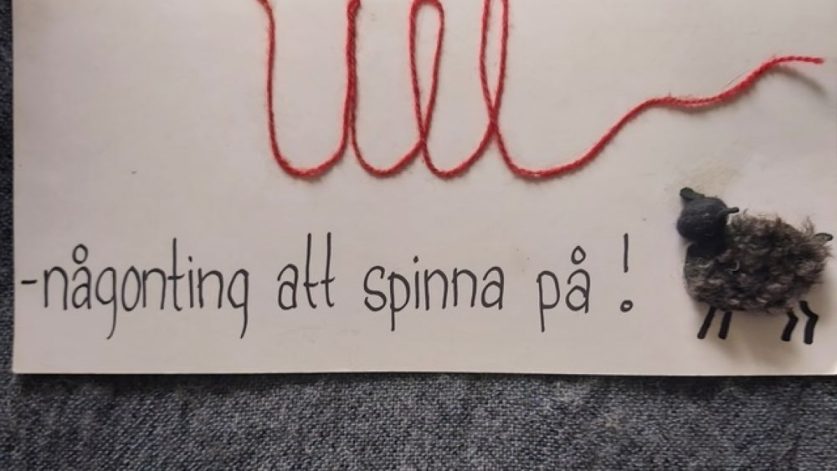 en etikett med texten ull-någonting att spinna på samt ett får