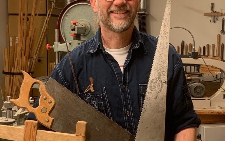 Martin Ericsson i en snickarverkstad där han håller i flera olika typer av sågar